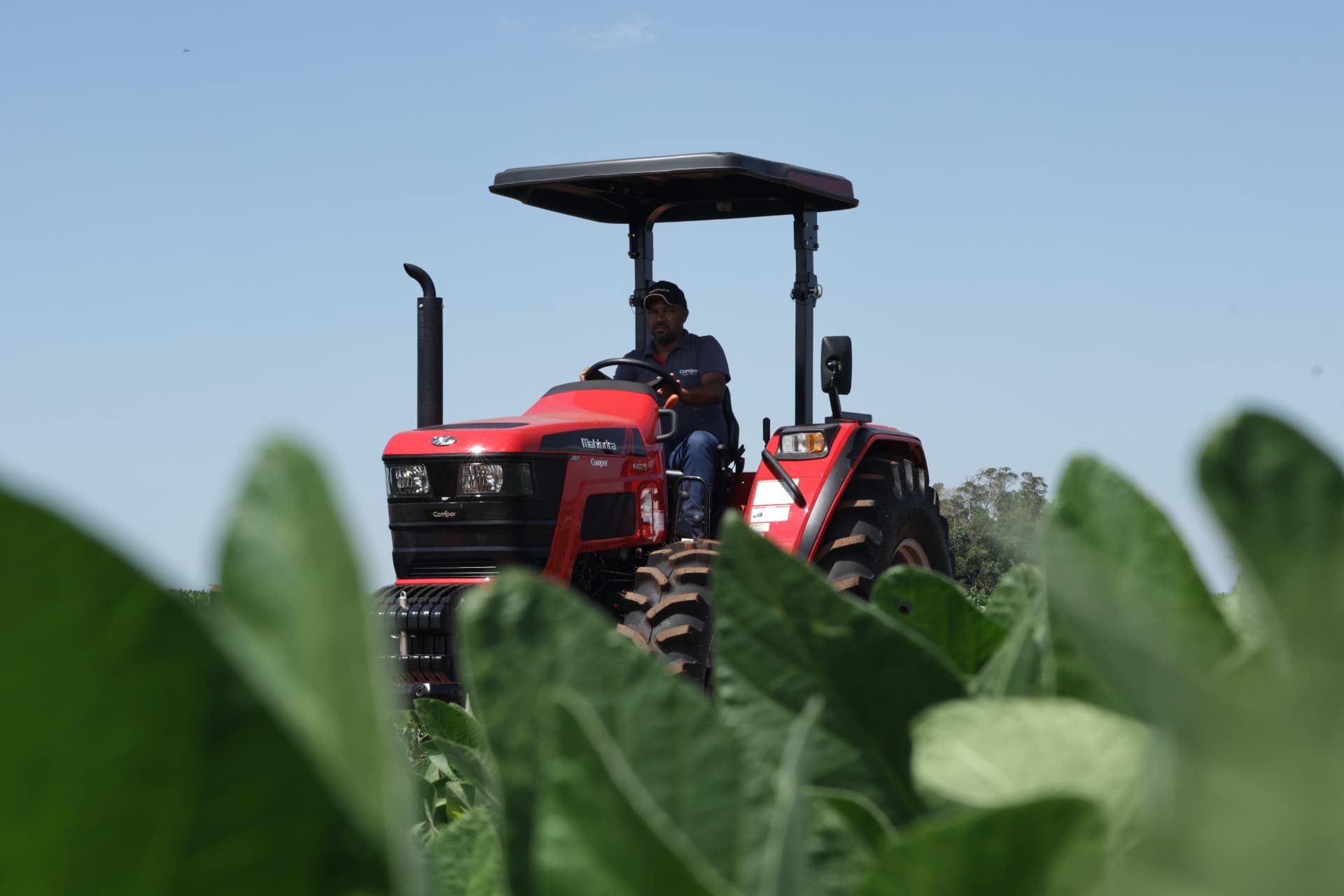 Produtor operando trator Mahindra em lavoura